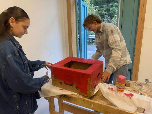 Amelia og William fra 8.trinn maler kasser som skal brukes for å bygge alteret.